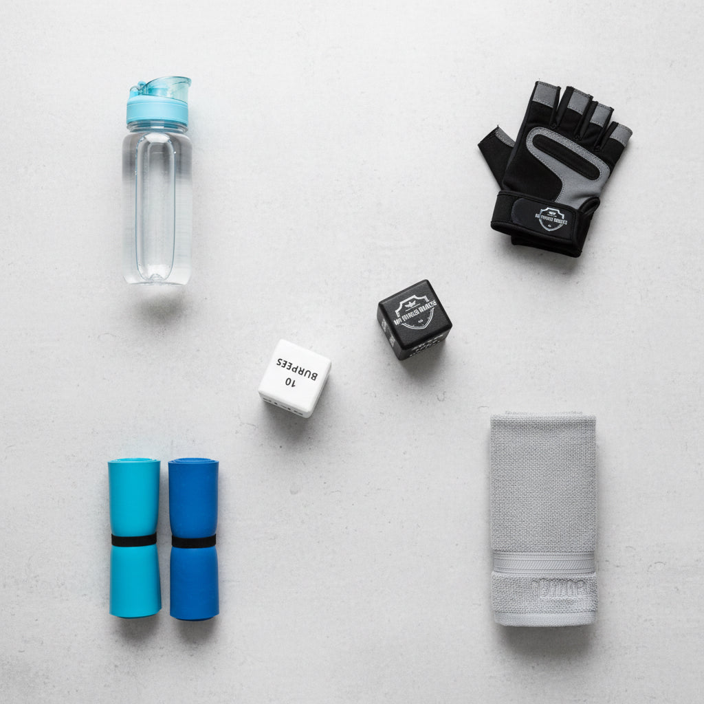 Black-and-white ROLKAH fitness dice beside workout accessories