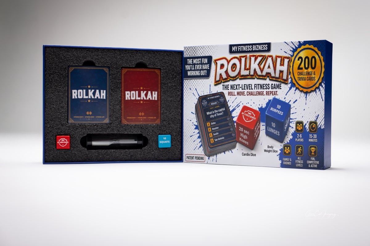 Open ROLKAH fitness game box with two card decks, fitness dice, hourglass, and box cover